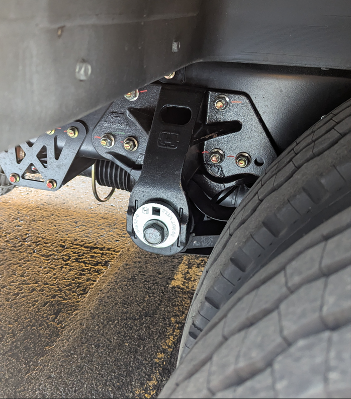 Rear pneumatic suspension front mounting bracket with adjuster